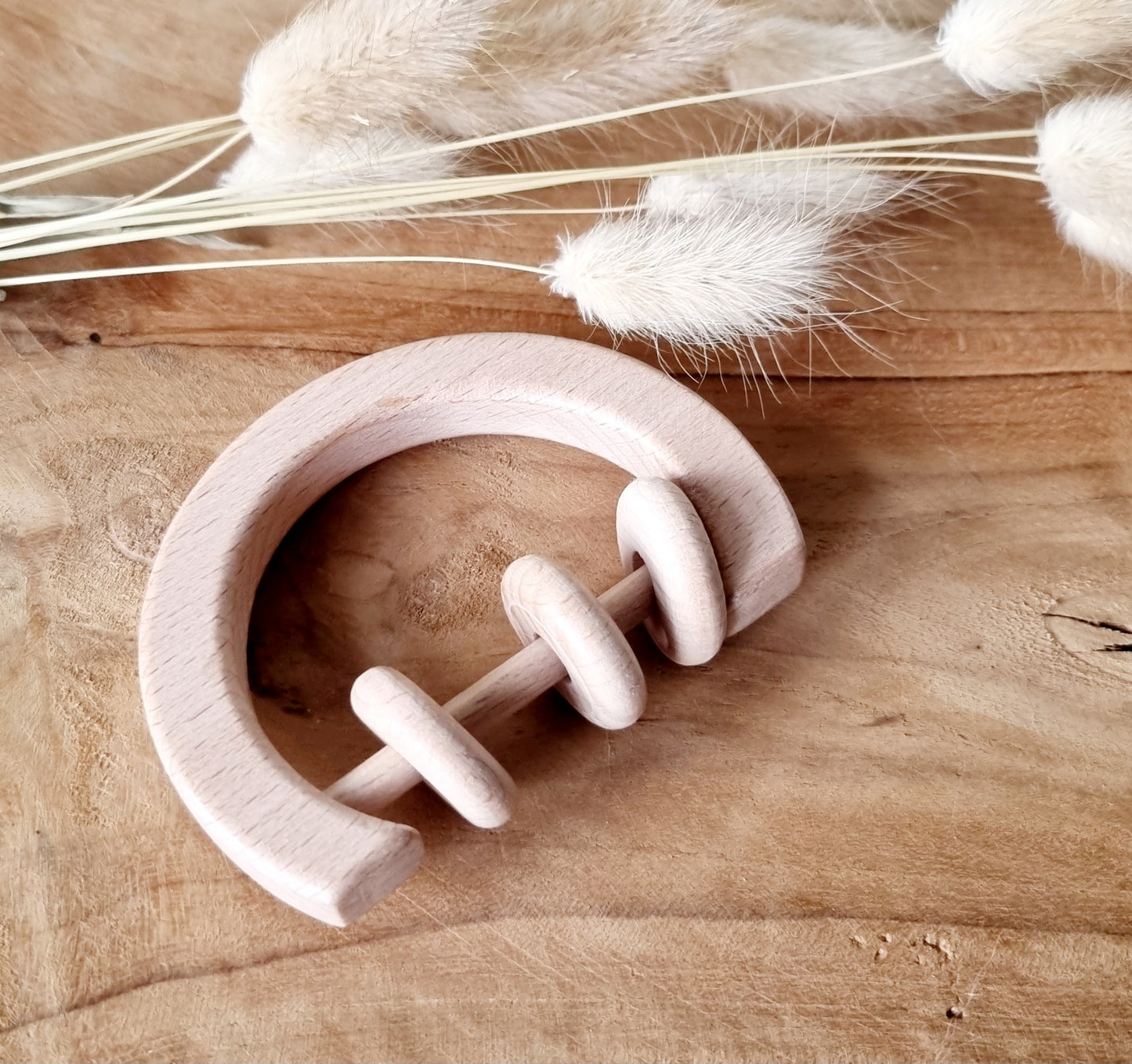 Houten rammelaar met ringen rond