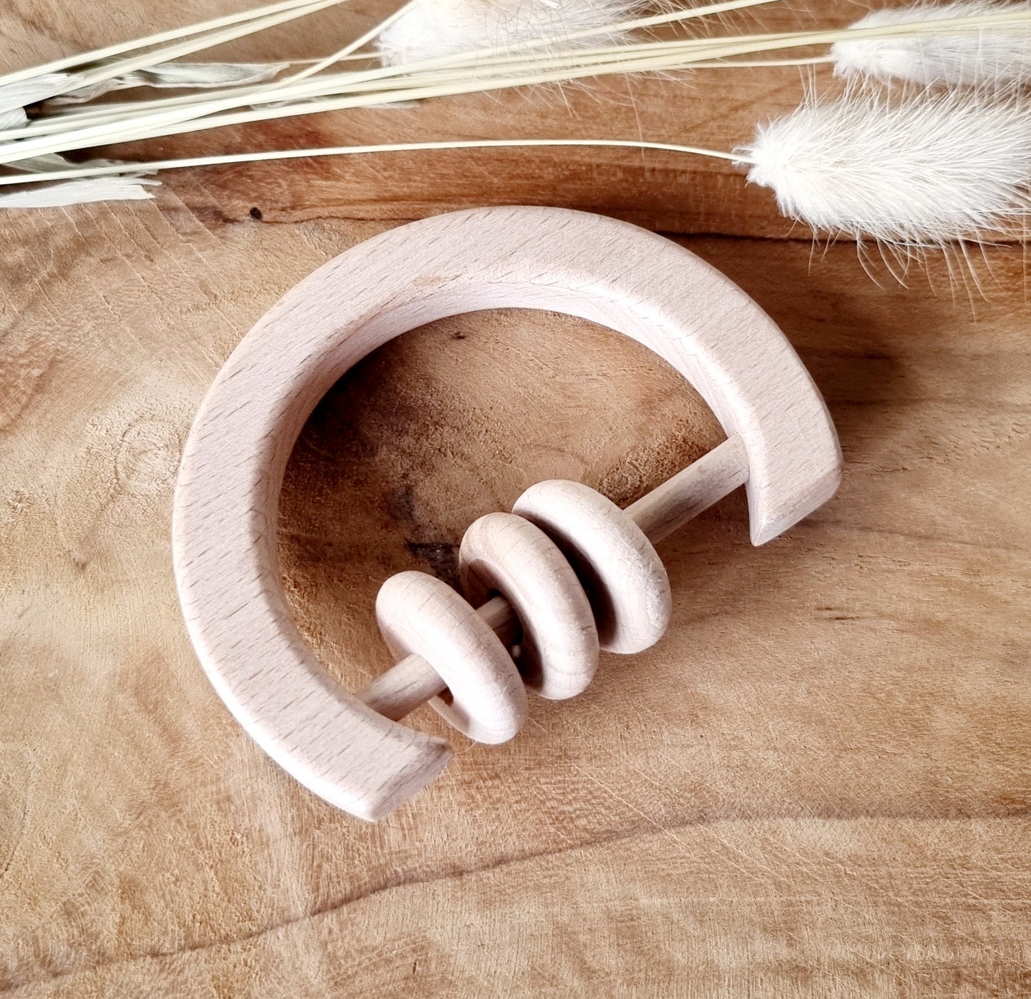 Houten rammelaar met ringen rond