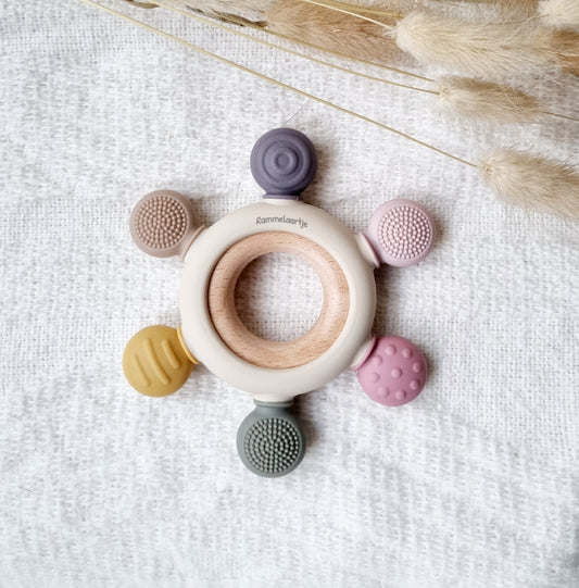 Deze stevige bijtring is echt een must-have! Het is gemaakt van een beukenhouten ring, en 100% babyveilige siliconen. Hierdoor is het flexibel, gemakkelijk vast te pakken, en erg fijn  om op te bijten.  Door het reliëf blijft het interessant en wordt het tandvlees gemasseerd.