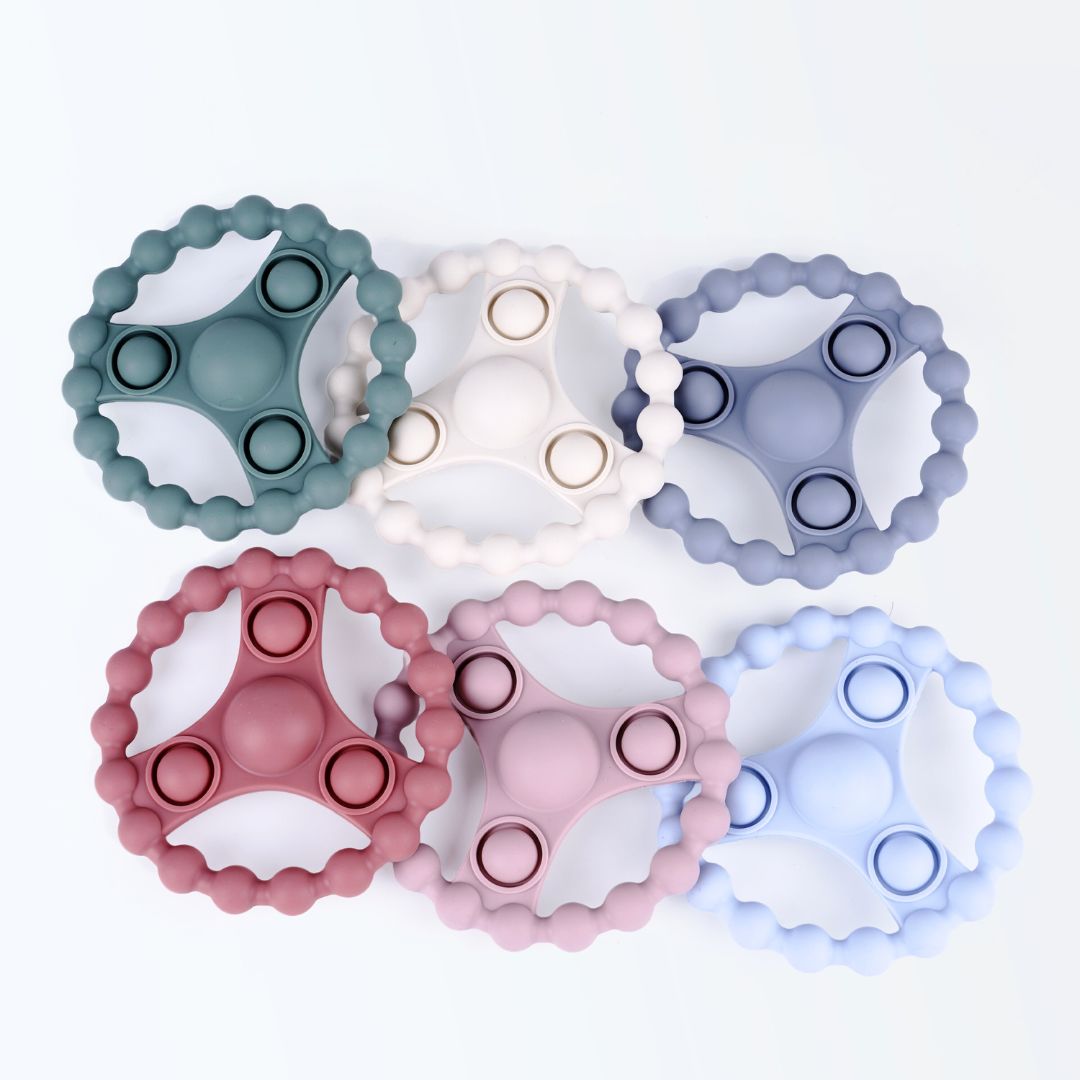 Zes siliconen bijtringen met pop-it functie in zachte Earthy Nordic kleuren van Rammelaartje, veilig babyspeelgoed tegen doorkomende tandjes.