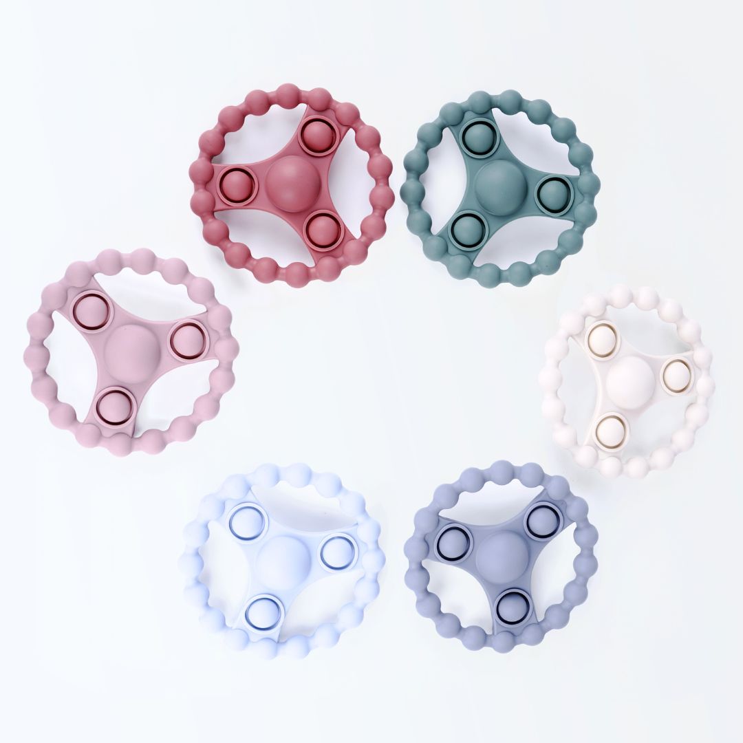 Zes siliconen bijtringen met pop-it functie in zachte Earthy Nordic kleuren van Rammelaartje, veilig babyspeelgoed tegen doorkomende tandjes.