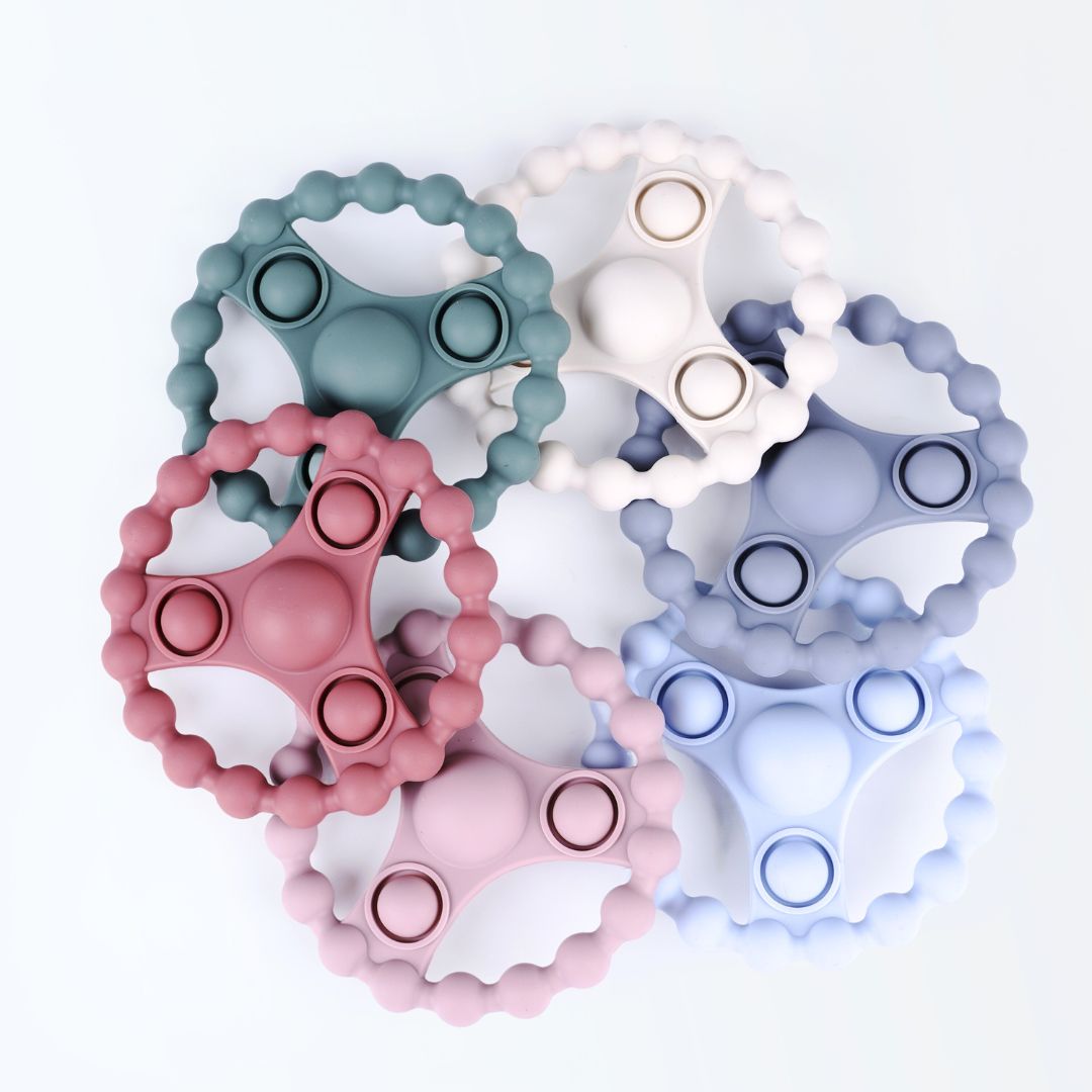 Zes siliconen bijtringen met pop-it functie in zachte Earthy Nordic kleuren van Rammelaartje, veilig babyspeelgoed tegen doorkomende tandjes.