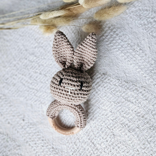Twee handgemaakte gehaakte konijn rammelaars in de kleuren zand en bruin, met houten ring – stijlvol babyspeelgoed van Rammelaartje
