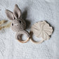 Twee handgemaakte gehaakte konijn rammelaars in de kleuren zand en bruin, met houten ring – stijlvol babyspeelgoed van Rammelaartje